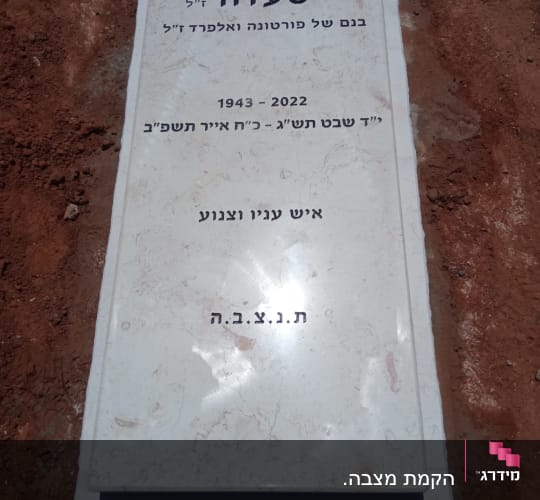 מצבה עם כיתוב בעברית על אדמה